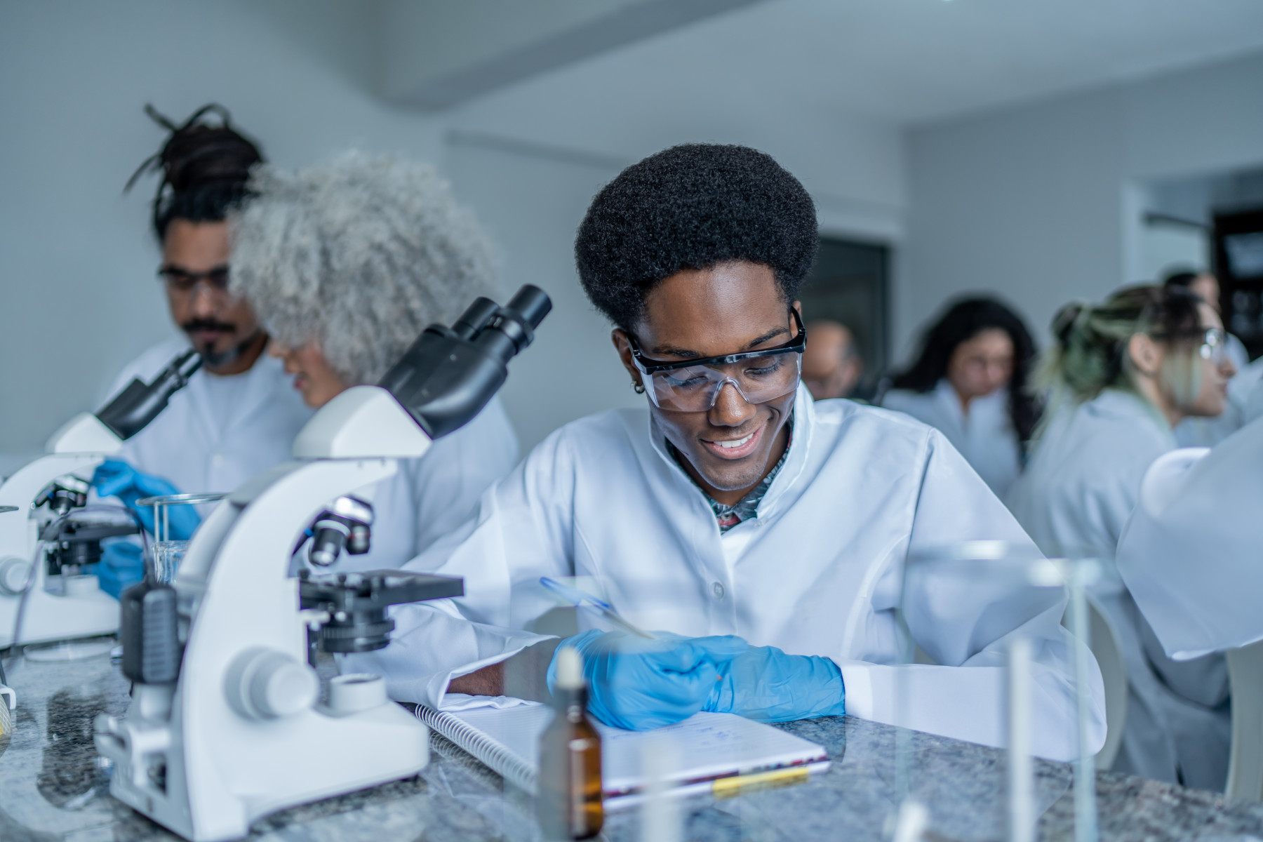 Researchers collaborate in a modern lab using scientific machinery and computers.